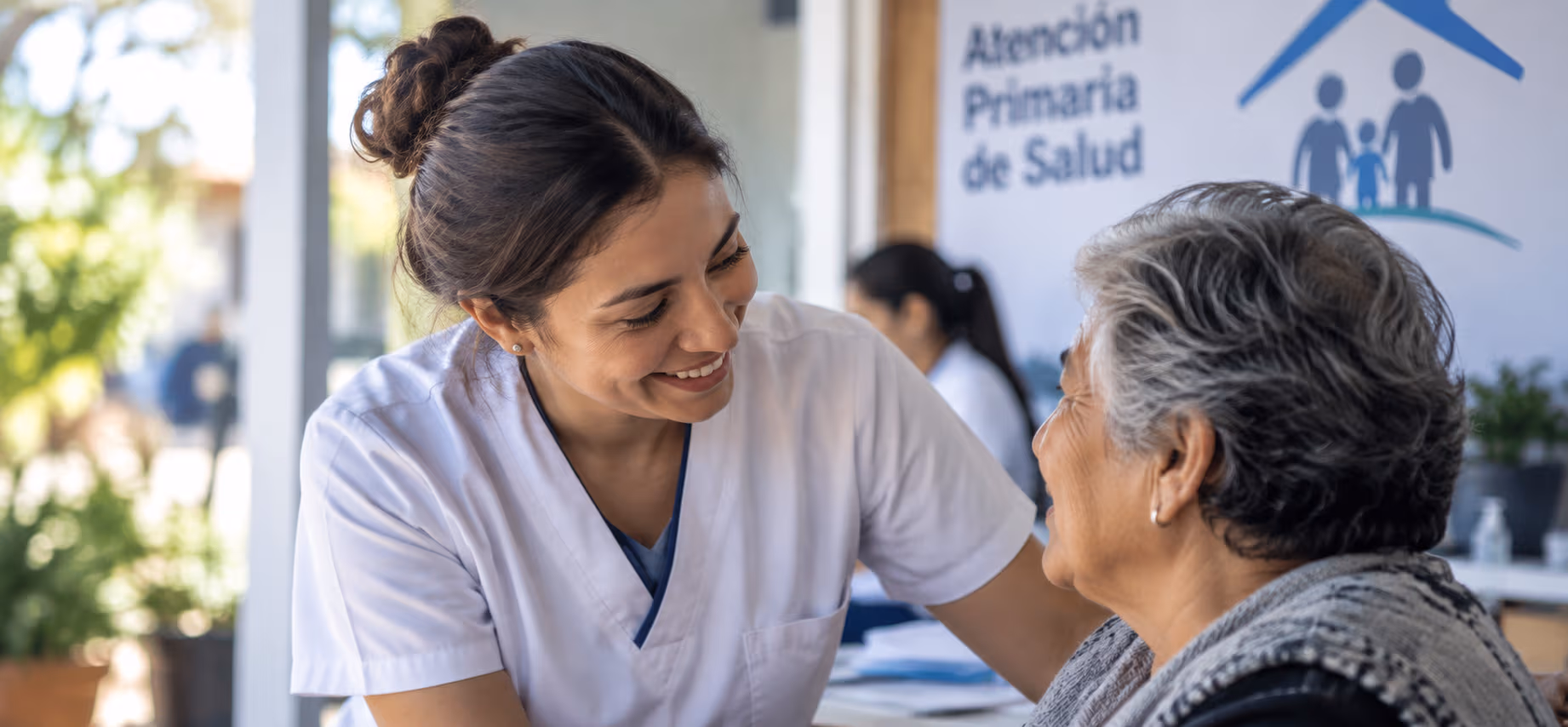 Enfermera de atención primaria sonriendo a una usuaria